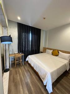 a hotel room with a bed and a table and a desk at 118 Orchid in Phú Quốc
