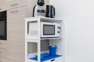 a microwave on a white shelf in a kitchen at Molino Lounge Express 20' da Milano e Malpensa in Saronno