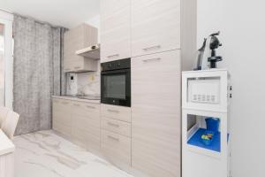 a kitchen with white cabinets and a black oven at Molino Lounge Express 20' da Milano e Malpensa in Saronno +20 photos