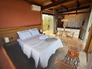 a bedroom with a large bed and a table at Chalé Mimosa in Sao Jorge