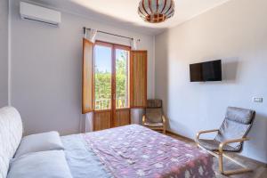 a bedroom with a bed and a chair and a window at Casa Matilde Vista Mare con Piscina by Wonderful Italy in Carrozziere – Fonte Ciane