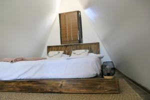 NucşoaraVictoriA-Frame的一间卧室配有一张带白色床单和枕头的木制床。