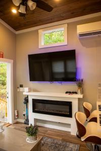a living room with a flat screen tv above a fireplace at Tiny Home - Grill, Near East Fork in Mentone