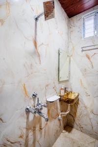 a marble bathroom with a sink and a mirror at Sunrise Hotel Shamshabad in Hyderabad +11 photos