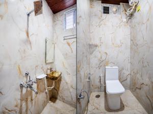 a marble bathroom with a toilet and a shower at Sunrise Hotel Shamshabad in Hyderabad +22 photos