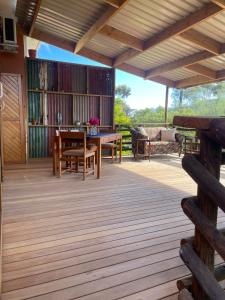a wooden deck with a table and a couch at Bokmakierie Studio in Montagu