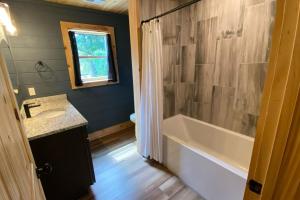 a bathroom with a tub and a sink at The Sundrop - Pool Table, Arcade Games, Outdoor Hot Tub, + Resort Access in Chalet Village +38 photos