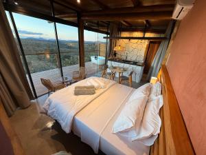 a bedroom with a bed and a view of a bathroom at Chalé Canela de Ema in Sao Jorge