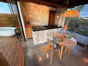 Un baño con mesa y bañera y una cocina. en Chalé Calliandra, en São Jorge