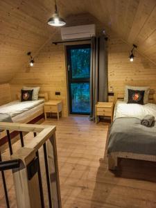 a room with two beds in a log cabin at Mazury Linowo - Domy z basenami in Linowo