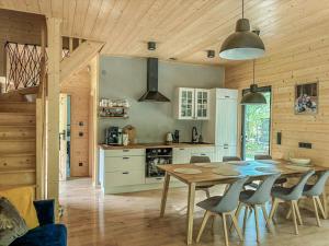 a kitchen and dining room with a table and chairs at Mazury Linowo - Domy z basenami in Linowo
