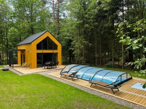 a yellow building with a swimming pool in a yard at Mazury Linowo - Domy z basenami in Linowo
