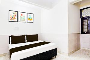 a white bedroom with a black and white bed at Super Hotel O Fazalpur in Delhi +21 photos