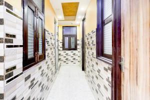 a hallway with tiled walls and a door at Super Hotel O Fazalpur in Delhi