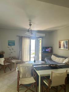 a living room with a couch and a table and chairs at Mikro Amoni Beach Villa in Pefkali