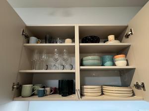 a cabinet filled with plates and cups and dishes at Apartmán Lima in Piešťany +11 photos
