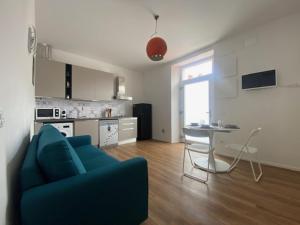 a living room with a blue couch and a kitchen at L'Albero in Bergamo +12 photos
