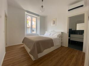 a white bedroom with a bed and a sink at L'Albero in Bergamo