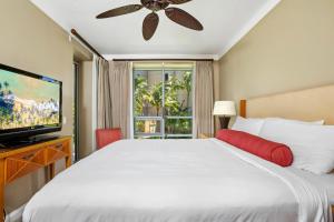 une chambre avec un lit blanc et une télévision à écran plat dans l'établissement Partial Ocean View 1-Bedroom Villas at Honua Kai Hokulani by KBM, à Kaanapali Airport