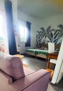 a living room with a bed and a couch at Leu Zarlor Location in Piton Saint-Leu