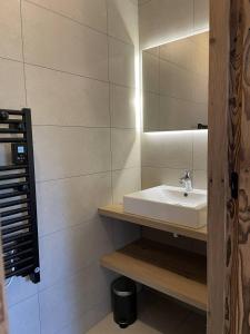 łazienka z umywalką i lustrem w obiekcie Appartement Haut de Gamme au cœur du village avec terrasse de 34m2 - 6 personnes w mieście Saint-Sorlin-dʼArves