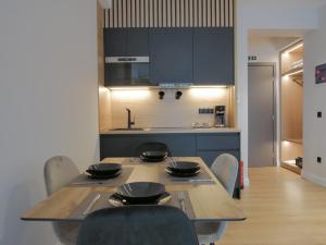 a kitchen with a wooden table with chairs and a tableasteryasteryasteryasteryastery at JKB Panoramic Suites in Athens