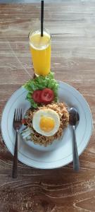 a plate of food with an egg and a drink at Gamat Sunset Cottage and Resto in Nusa Penida