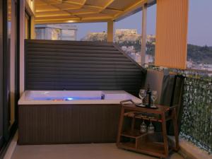 a hot tub on a balcony with a table at JKB Panoramic Suites in Athens