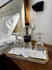 a tray with a bottle and two glasses on a bed at Міні-готель Три Корони in Lviv +7 photos