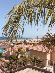 Una vista de la playa desde el balcón de un resort. en SANTA ANA 8, en Maspalomas