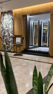 a lobby with a sign in the middle of a building at Artama Hotel in Unayzah