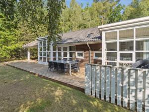 a house with a wooden deck with a table at Holiday Home Dorit - 600m from the sea by Interhome in Hasle