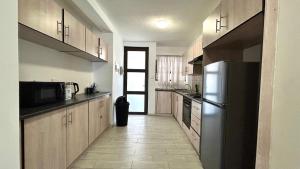 a kitchen with wooden cabinets and a refrigerator at A-Lux BnB in Ongwediva