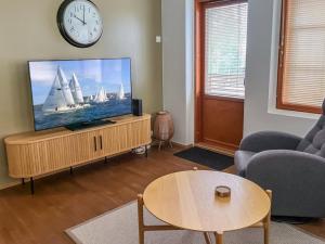 a living room with a tv and a clock on the wall at Holiday Home Karhunvartijan linna a1 by Interhome in Ruka
