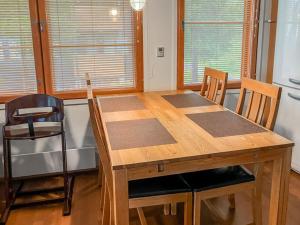 a wooden table and chairs in a kitchen with windows at Holiday Home Karhunvartijan linna a1 by Interhome in Ruka