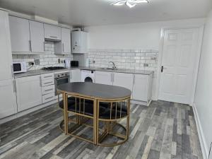 a kitchen with white cabinets and a table in it at One bedroom flat in Barking +15 photos
