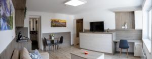 a living room with a couch and a kitchen with a tv at HunGasthaus 05&06 in Mariazell +11 photos