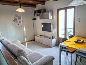 een woonkamer met een bank, een tafel en een televisie bij Holiday Home Lo Scoiattolo by Interhome in Carmine