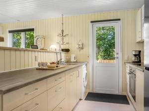 a kitchen with white cabinets and a white door at Holiday Home Gunhil - 200m from the sea by Interhome in Hals