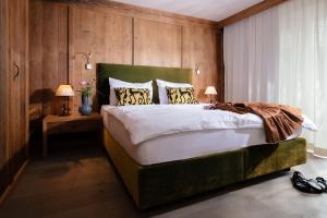 Un dormitorio con una cama grande con paredes de madera. en Hotel Quellenhof, en Leutasch 54 fotos más
