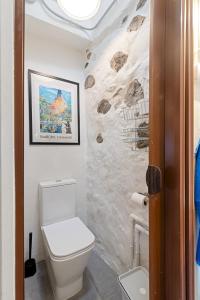 a bathroom with a toilet and a picture on the wall at Home2Book Charming Rustic Retreat in Telde in Telde +18 photos