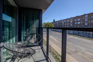 a balcony with two chairs and a view of a street at AboutArtApartments - Krzywoustego in Wrocław