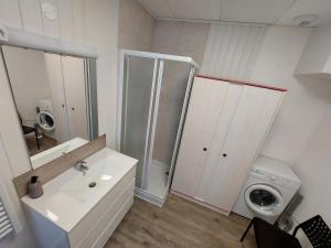 a bathroom with a sink and a washing machine at Gîte St Gobain in Saint-Gobain