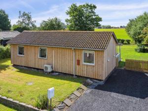 a small wooden cabin in a yard at Holiday Home Henric - 500m from the sea by Interhome in Strøby