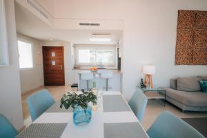 a living room with a table and blue chairs at Luxury Penthouse Alcazaba Lagoon 521 - EHHouse in Estepona +37 photos