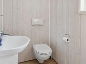 a bathroom with a white toilet and a sink at Holiday Home Fenja - 1-2km from the sea by Interhome in Marielyst