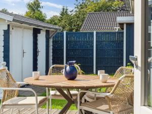 a wooden table with chairs and a vase on it at Holiday Home Asvalde - 200m to the inlet by Interhome in Vordingborg +19 photos