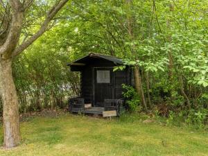 a small black shack in the middle of a forest at Holiday Home Zekine - 700m from the sea by Interhome in Dannemare