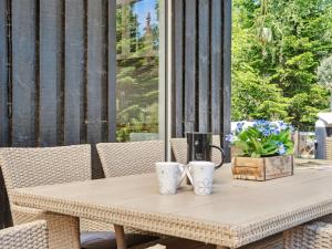 a table with two cups on it on a patio at Holiday Home Thorlak - 860m from the sea by Interhome in Marielyst