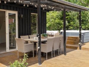 a patio with a table and chairs on a deck at Holiday Home Thorlak - 860m from the sea by Interhome in Marielyst +17 photos